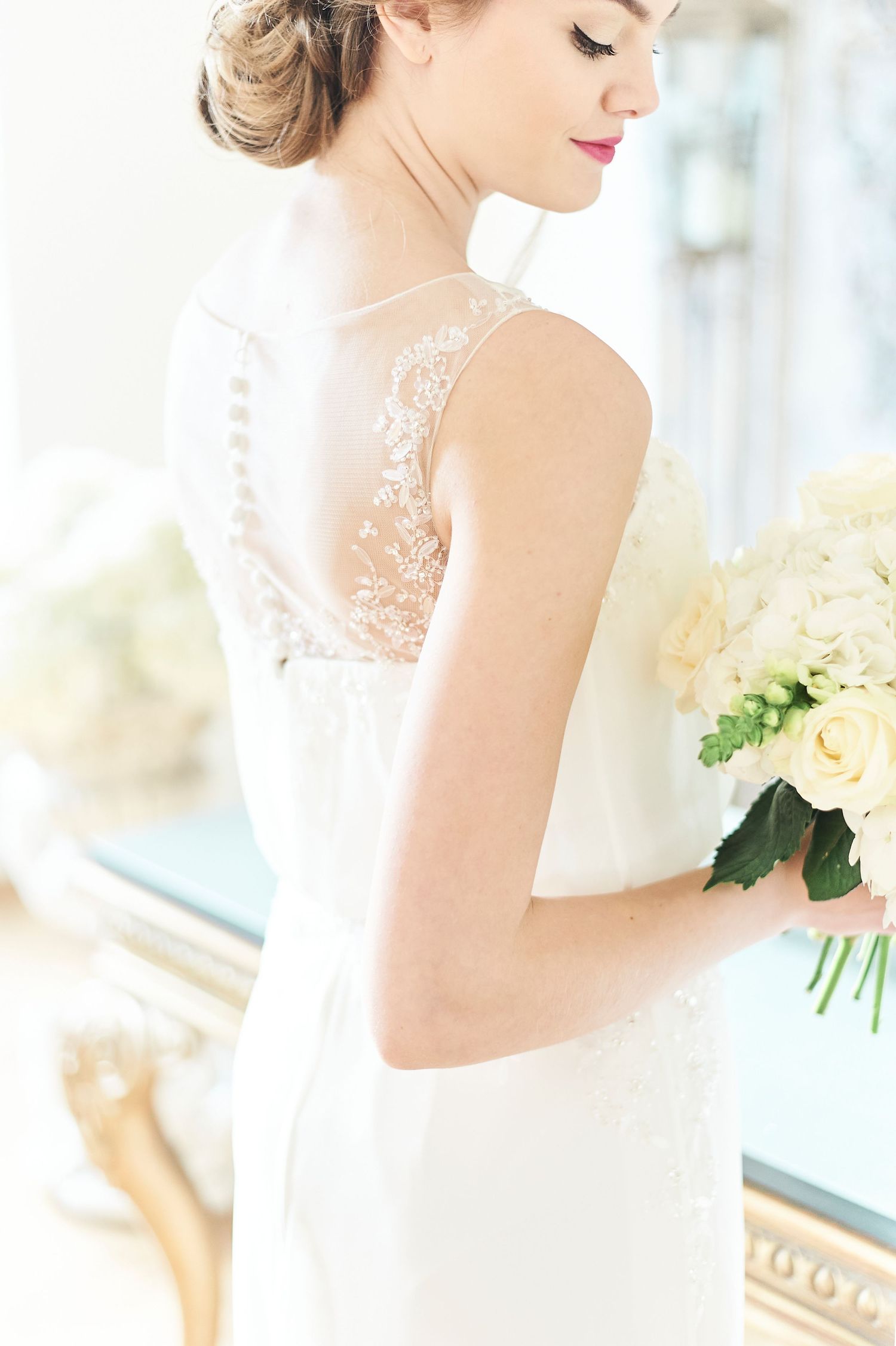 portrait of bride looking down at bouquet at luxury Oxnead Hall wedding. by Norfolk best wedding photographer Faye Amare