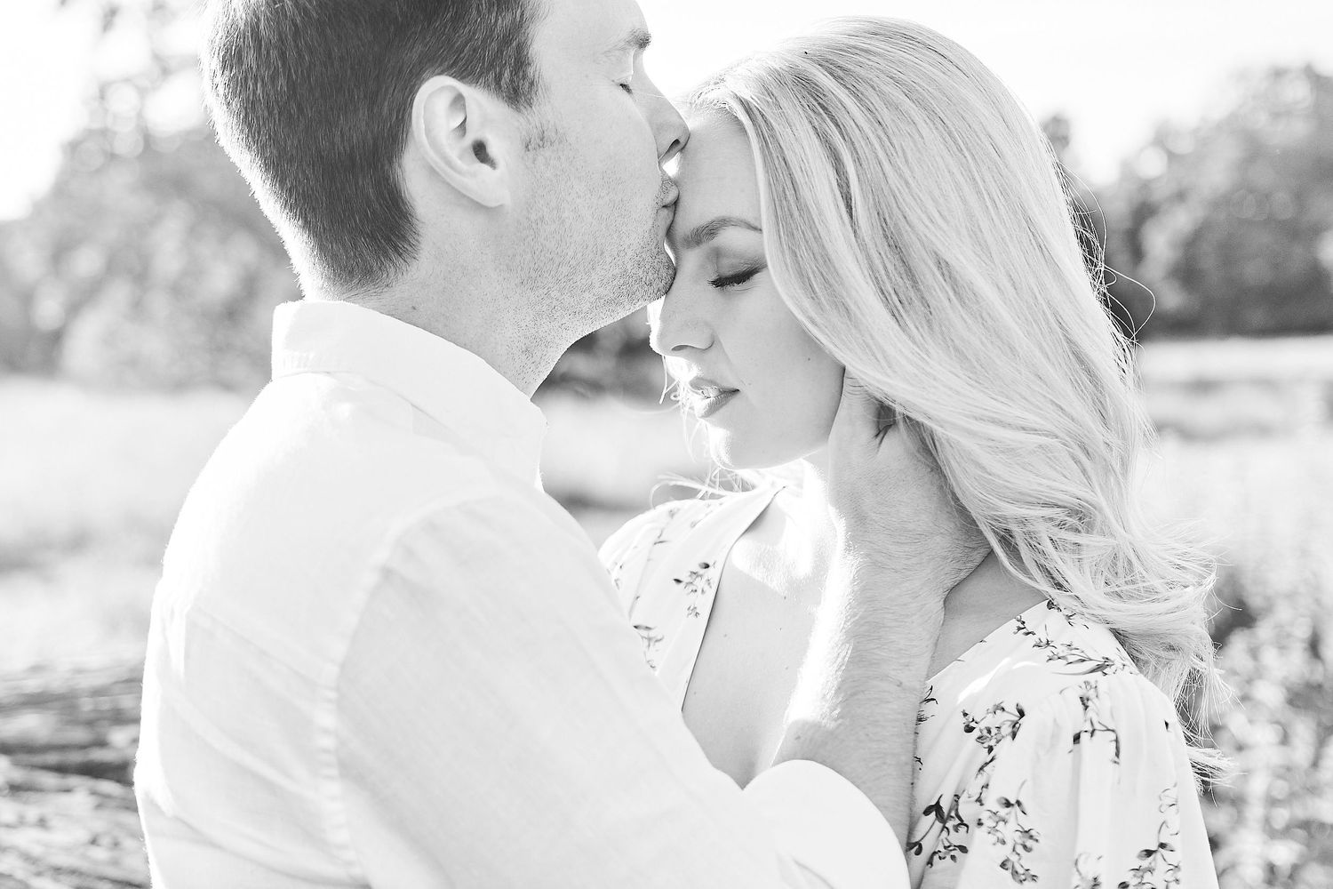 man kisses women on forehead in norfolk's wildflower meadow by award winning norfolk wedding photographer Faye Amare