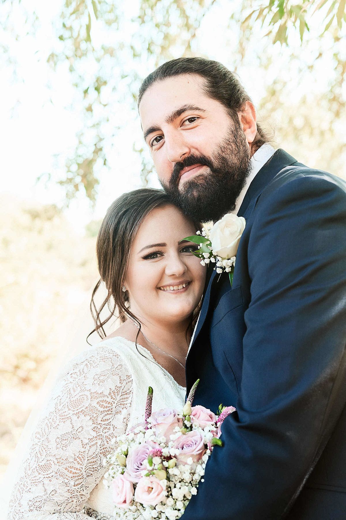 bride and groom stand for portraits in field at sunset by Norfolk Wedding Photography Faye Amare